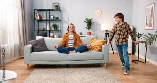 Foto Beautiful Caucasian mom parent sitting on couch meditating with calm face and cl