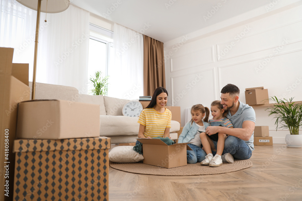Happy family unpacking moving box at their new house Happy family unpacking moving box at their new house