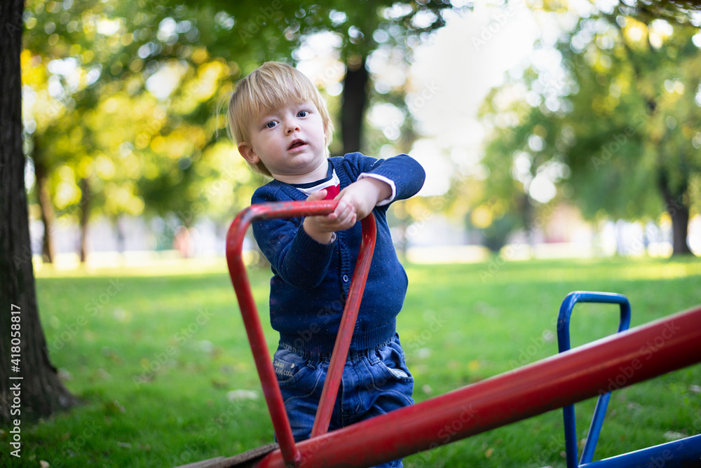 Little blue boy of 1 year on the playground Little blue boy of 1 year on the playground