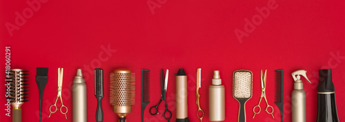 Fotografie Modern hairdresser tools arranged in a line on red background