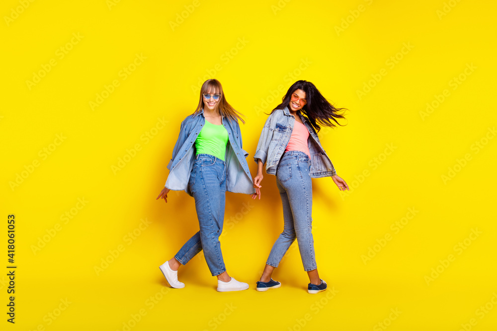 Full size profile portrait of two charming cheerful persons diversity toothy smile isolated on yellow color background Full size profile portrait of two charming cheerful persons diversity toothy smile isolated on yellow color background
