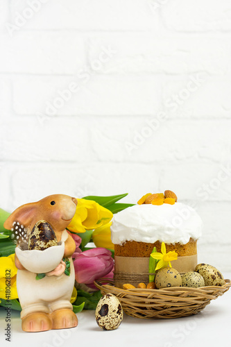 Easter  bunny  and Eastr cake   on white background  with  bouquet yellow tulip .copy space .  vertical .Happy Easter  morning Holidays concept. © Tetiana