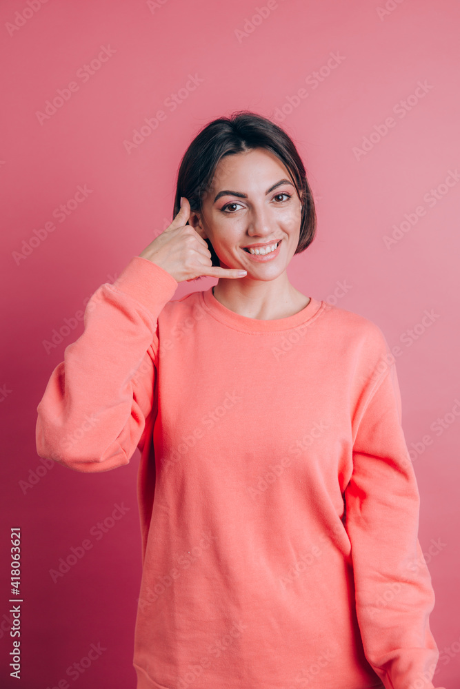 Woman wearing casual sweater on background smiling doing phone gesture with hand and fingers like talking on the telephone Woman wearing casual sweater on background smiling doing phone gesture with hand and fingers like talking on the telephone