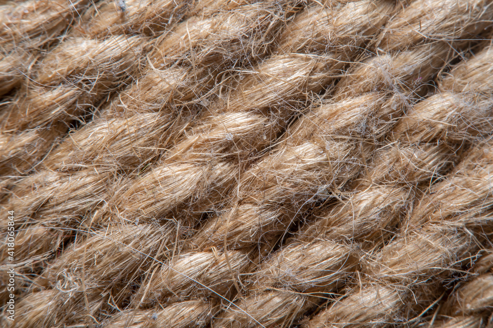 Obraz premium A background of roughly knitted fabric in soft focus under high magnification. Synthetic fabric stylized as an old, chunky-knit linen thread.