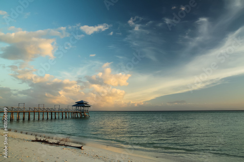 Wooden pier over sea water against the background of the sky during sunset © KANSTANTSIN