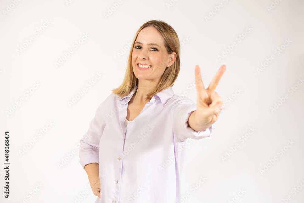 Blonde woman over isolated background smiling and showing victory sign Blonde woman over isolated background smiling and showing victory sign