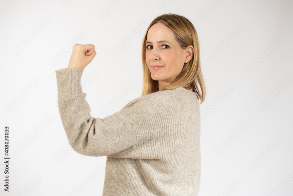 Smiling young woman over isolated white background doing strong gesture Smiling young woman over isolated white background doing strong gesture
