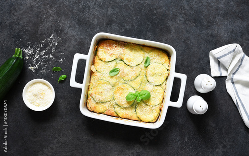 фотографія Zucchini gratin with bechamel sauce and parmesan on a dark concrete background