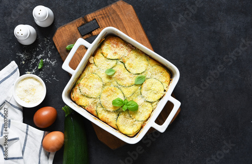 Φωτογραφία Zucchini gratin with bechamel sauce and parmesan on a dark concrete background