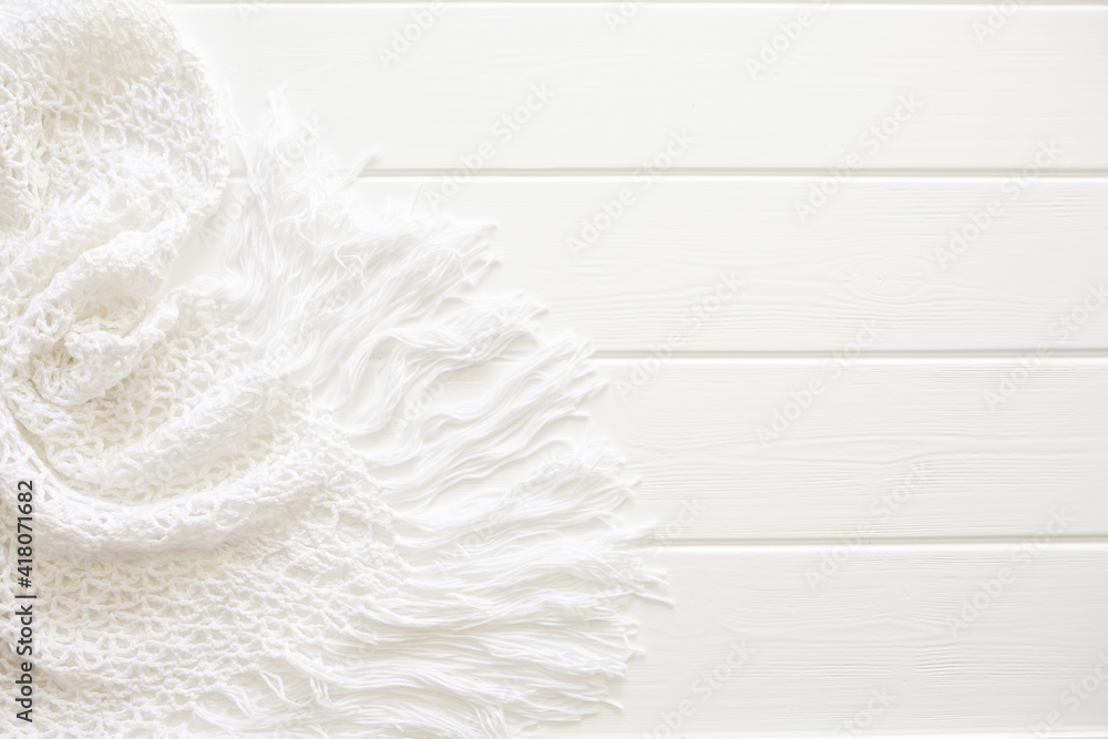 Obraz premium A white knitted dress lies on a white wooden deck chair. Swimwear, leisure wear. Vacation concept on the beach, with copy space and place for text.