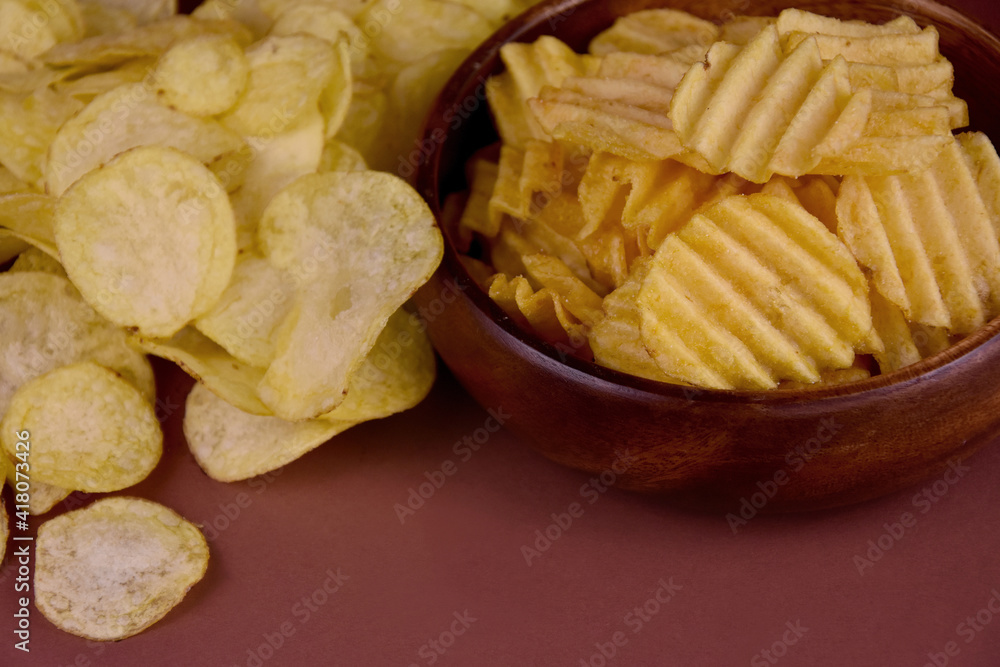 Salty potato chips close-up stock images. Fried potato chips on a brown background stock photo. Salty and spicy potato chips images Salty potato chips close-up stock images. Fried potato chips on a brown background stock photo. Salty and spicy potato chips images