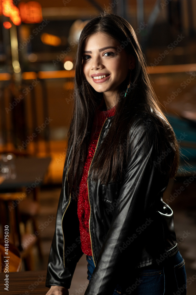 Portrait of a pretty young woman standing stylishly in a restaurant, customer concept.