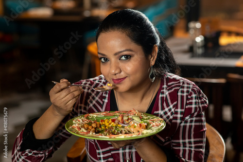 Portrait of a pretty woman eating delicious food in a restaurant.