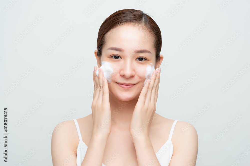 Portrait of cheerful laughing woman applying foam for washing on her face. Portrait of cheerful laughing woman applying foam for washing on her face.