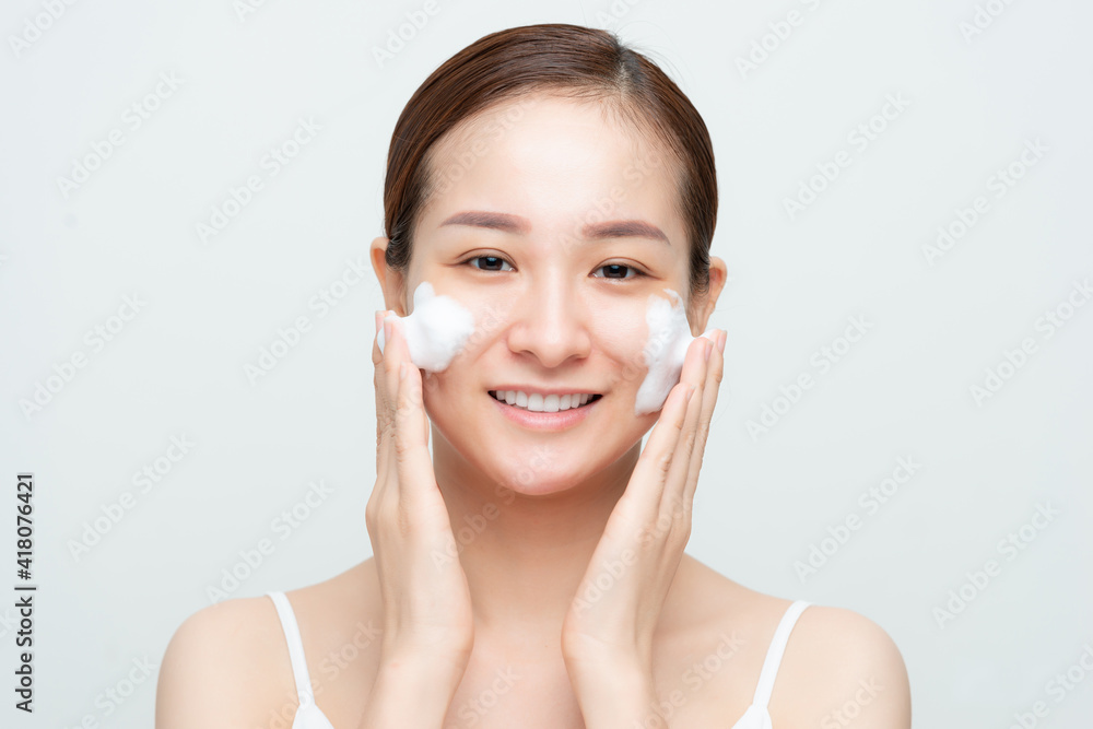 Attractive beauty young Asian woman washing up her face with foam cleanser in the morning.