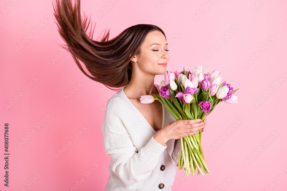 Profile side photo of calm sweet cute young lady smell flowers hold hands hair fly isolated on pink color background