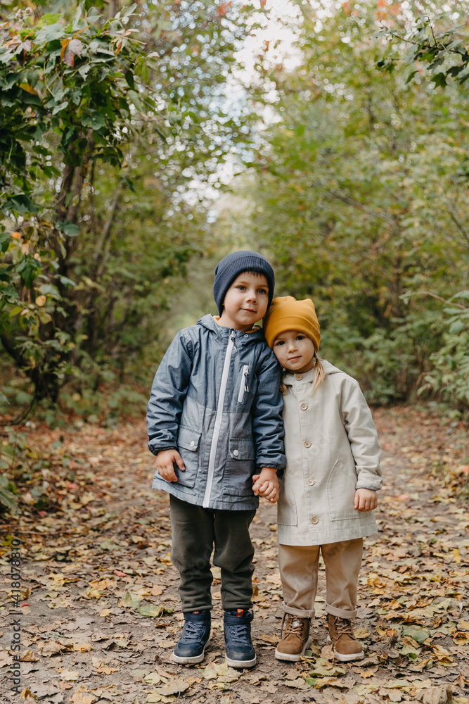 Fototapeta premium beautiful couple of children, boy and girl have a sincere friendship with each other and have fun and pose for a photo on a walk in the park