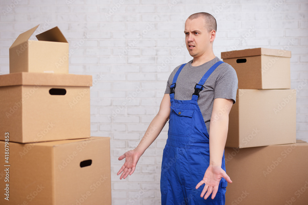 Shocked loader looking on boxes over brick wall Shocked loader looking on boxes over brick wall
