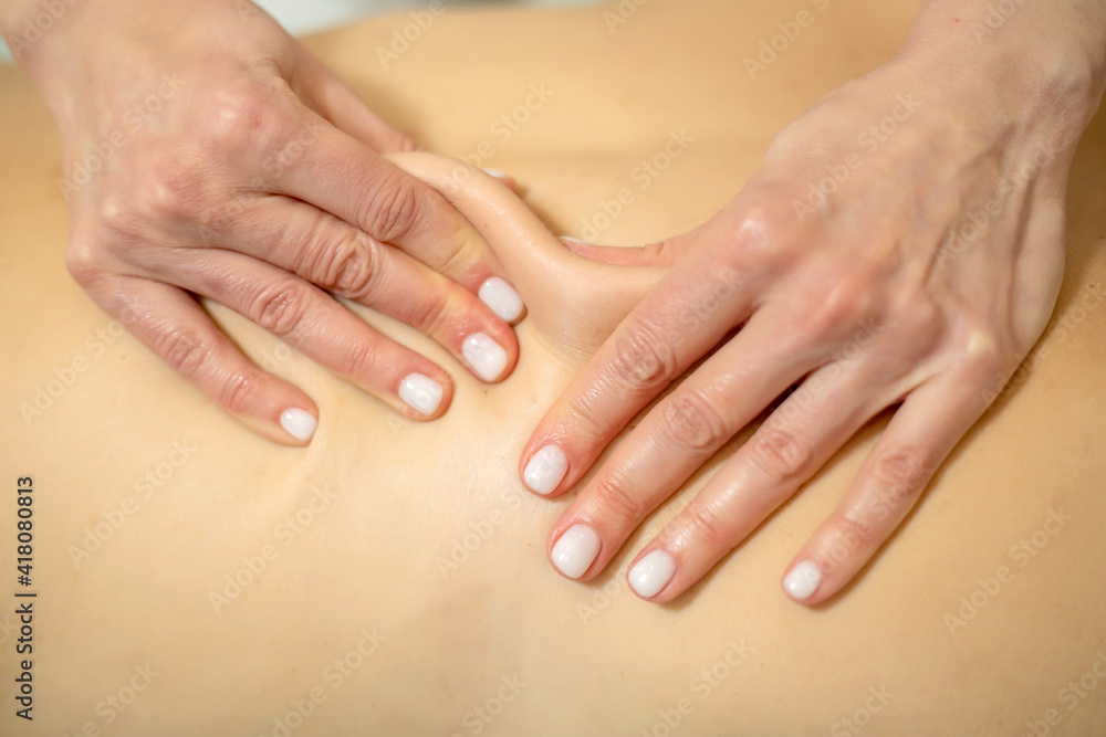 Young woman relaxing with hand massage at beauty spa.