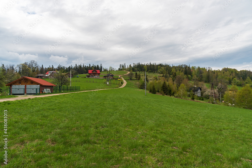 Ceslar hill in Slezske Beskydy mountains on czech - polish borders with meadow, few houses and trees