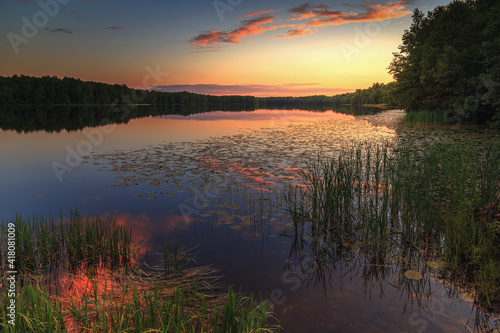 Beautiful sunset. Lake in the forest in summer. Landscape © Aleksei