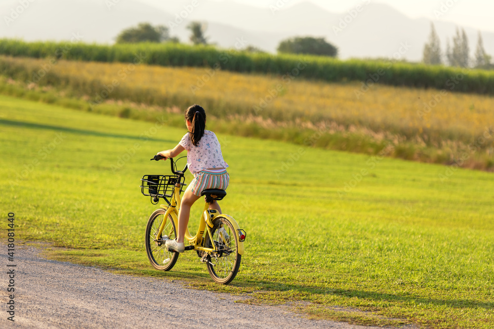 Family Happy.  Asia gird happy and relax outdoor with bicycling at the garden meadow in sunset.  Lifestyle Family Concept