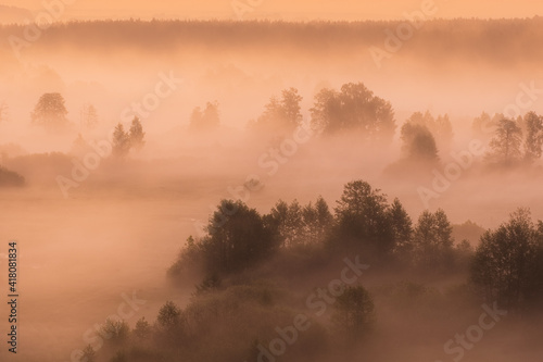 Beautiful countryside sunrise landscape. Early morning fog rolling over scenic green landscape. Aerial view. HDR photography