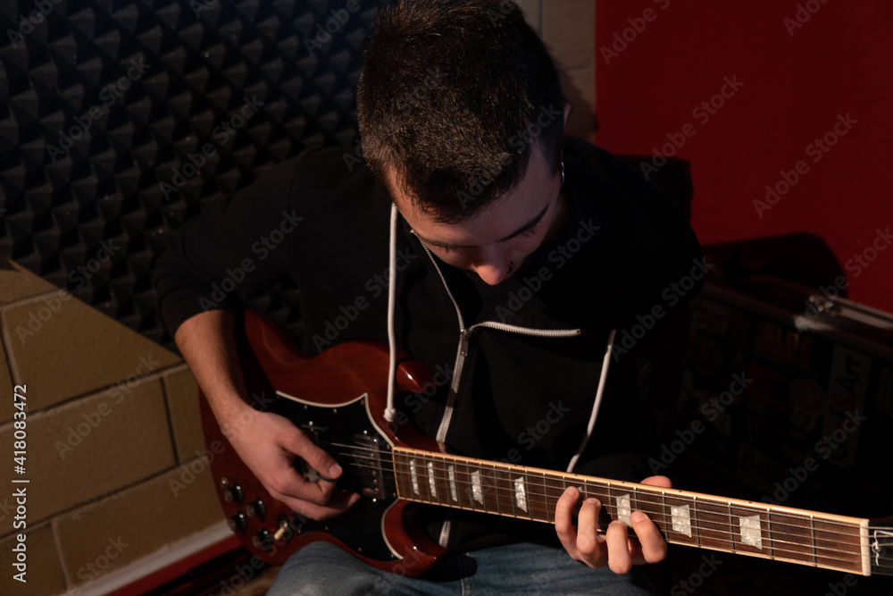 Obraz premium Man playing the guitar at the studio