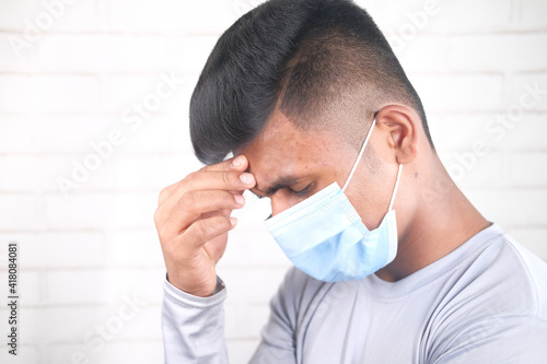A young asian man with protective mask in face feeling sad 