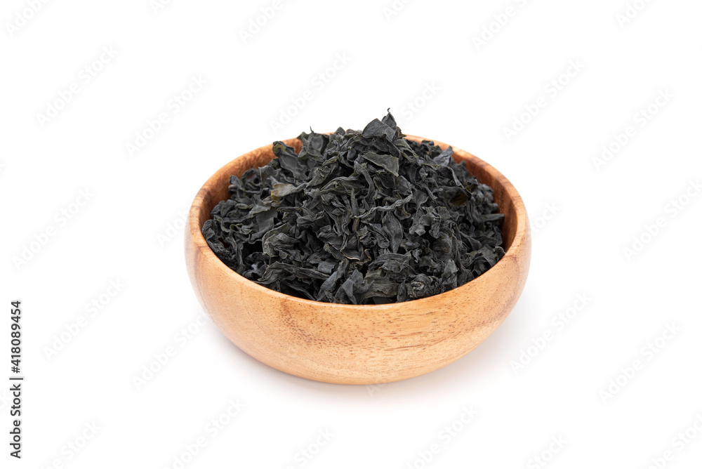 Dried seaweed wakame in wooden bowl isolated on white background. Japanese food Dried seaweed wakame in wooden bowl isolated on white background. Japanese food