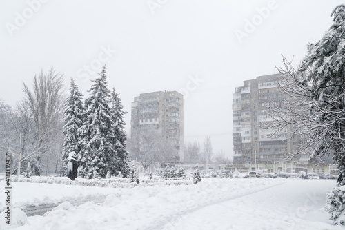 Fotografie Snow-covered winter street in a city, trees covered with ice and snow, sleet load