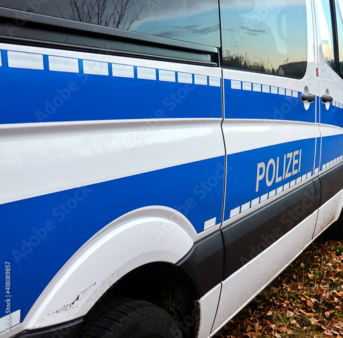 Oblique side view of a blue and white German police transporter