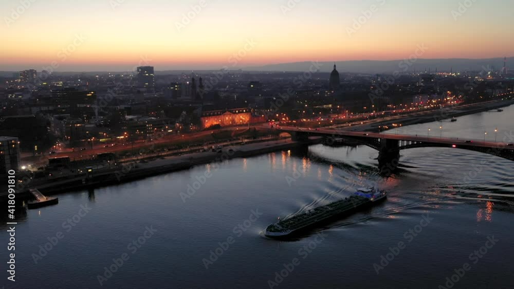 Mainz with an aerial drone view at magic hour showing the city with lights and a ship on the Rhine river Mainz with an aerial drone view at magic hour showing the city with lights and a ship on the Rhine river