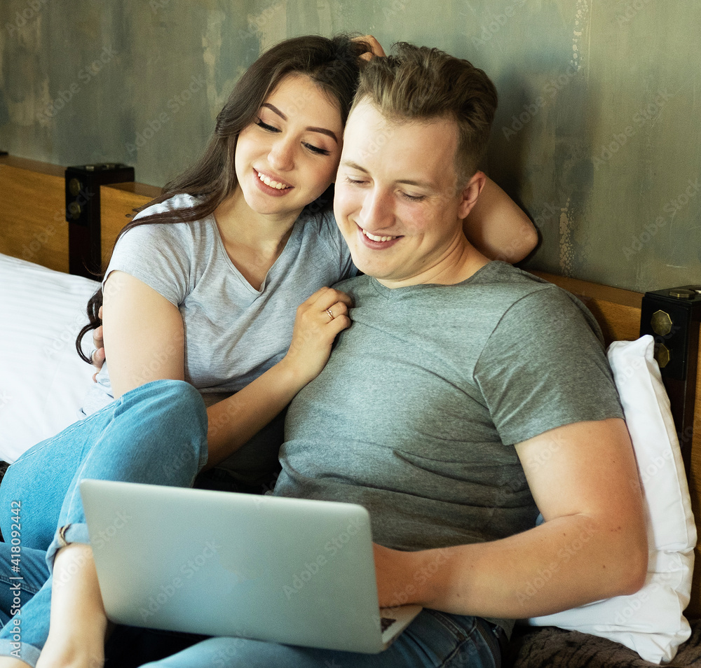 Lifestyle. tehnology and people concept: young couple with digital laptop resting on bed at home Lifestyle. tehnology and people concept: young couple with digital laptop resting on bed at home