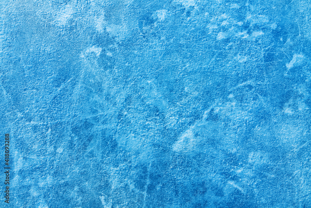 Ice blue background with ice skating tracks. Covered with a thin layer of snow. Rink. Frozen water, sea. Frosty ice texture with scratches in winter. Ice blue background with ice skating tracks. Covered with a thin layer of snow. Rink. Frozen water, sea. Frosty ice texture with scratches in winter.