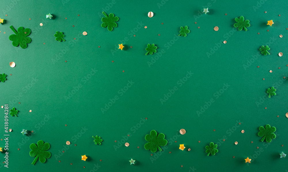 Happy St. Patricks Day decoration concept. Flat lay, top view of clover leaves on green background with space for text.