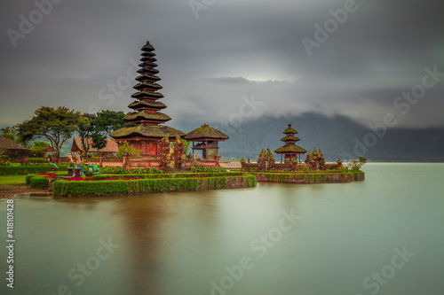 Pura Ulun Danu Bratan temple in Bali island. Beautiful balinese temple during sunrise. Balinese landmark. Cloudy sky. Water reflection. Slow shutter speed. Bratan lake, Bali