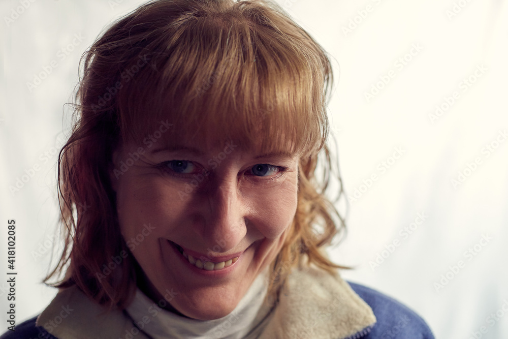 Portrait of fun middle-aged woman on a white background. Unprofessional female model with shy smile awkwardly posing in the Studio. Portrait of fun middle-aged woman on a white background. Unprofessional female model with shy smile awkwardly posing in the Studio.
