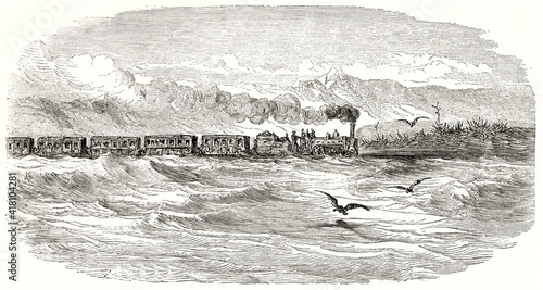 train arrival around Barcelona surrounds, Spain, snorting in horizontal side view so close to waved sea. Ancient grey tone etching style art by Dore, Magasin Pittoresque, 1838