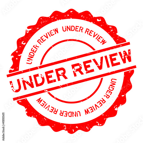 Grunge red under review word round rubber seal stamp on white background