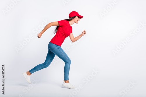 Full size profile side photo of young happy cheerful excited delivery girl run fast in air isolated on grey color background © deagreez