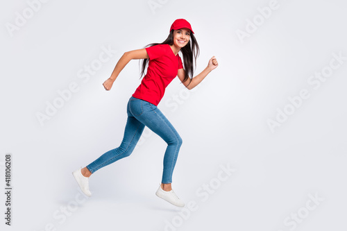 Full size profile side photo of young happy excited delivery girl running in air fast speed isolated on grey color background © deagreez
