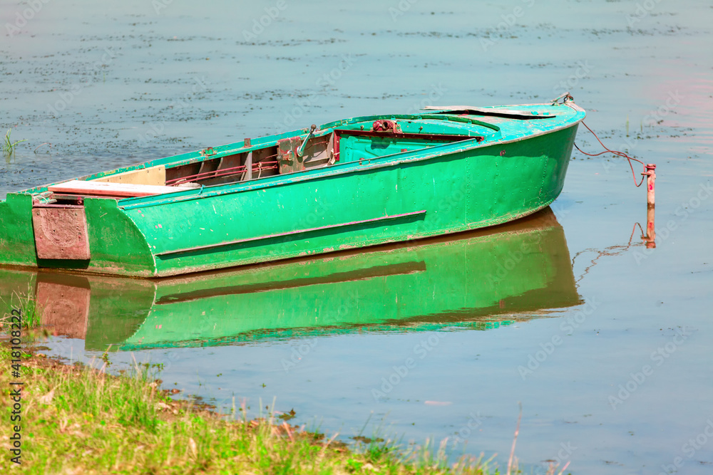 Green fishing boat moored near to the shore . Old fishing vessel Green fishing boat moored near to the shore . Old fishing vessel