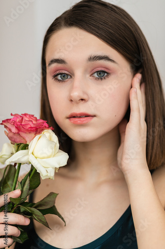 Portrait of beautiful dark-haired woman with flowers. Fashion photo  Pretty little girl with pink rose