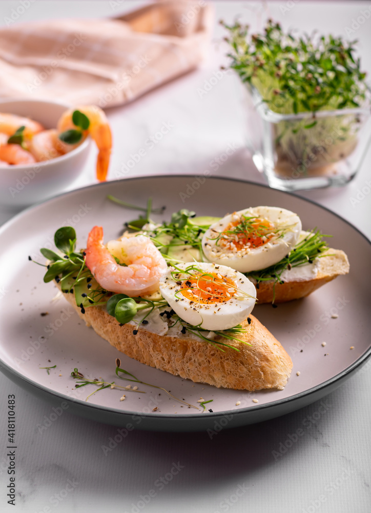 Breakfast with bruschetta with shrimps, eggs and microgreens in a plate Breakfast with bruschetta with shrimps, eggs and microgreens in a plate
