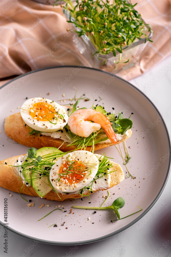 Breakfast with bruschetta with shrimps, eggs and microgreens in a plate Breakfast with bruschetta with shrimps, eggs and microgreens in a plate