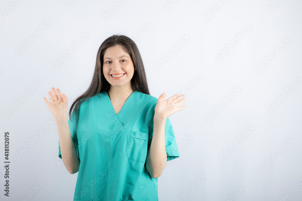 Smiling nurse holding her hand up and looking at camera Smiling nurse holding her hand up and looking at camera