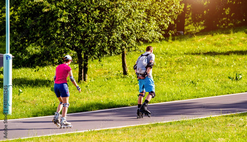 Obraz premium A man and a woman ride on roller skates 