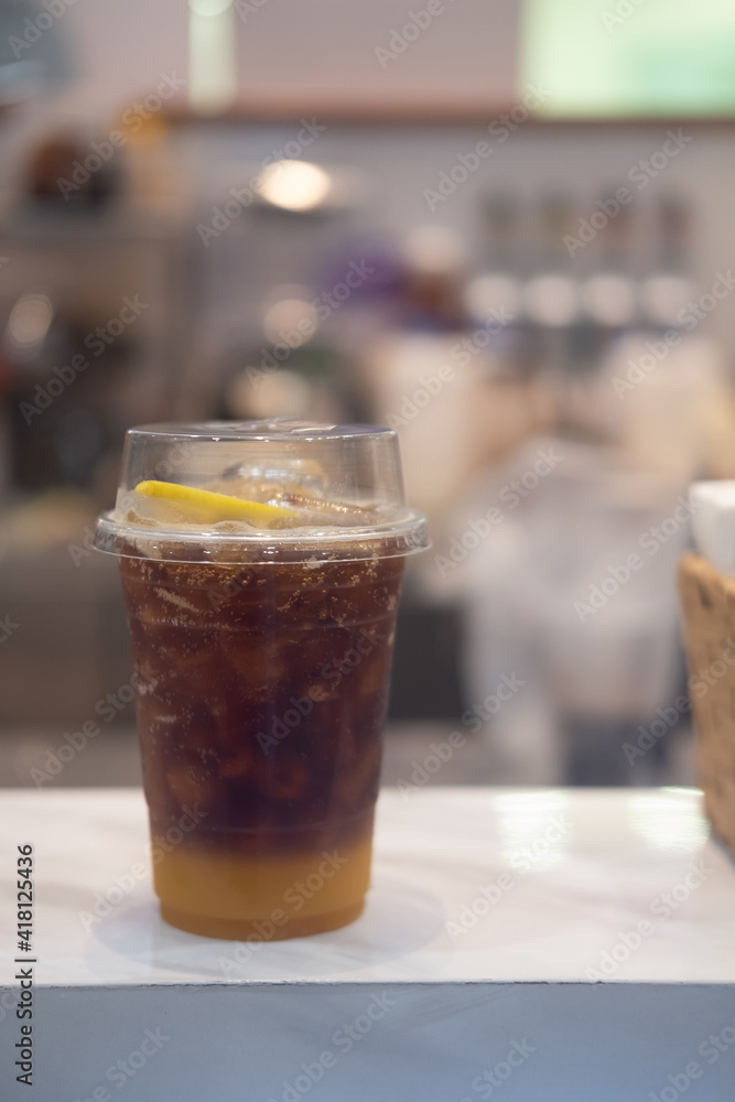 A plastic glass of espresso mixed with craft soda and orange juice and topping with orange slice. A plastic glass of espresso mixed with craft soda and orange juice and topping with orange slice.