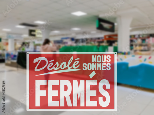 SORRY WE ARE CLOSED lettering in French. Empty stores work restriction during global pandemic of Covid-19